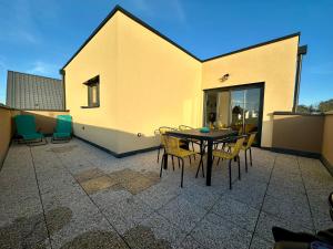 a patio with a table and chairs on a building at Europ-Appart --- Europa-Park-Rulantica in Huttenheim