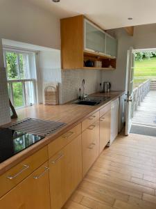 a kitchen with wooden cabinets and a wooden floor at Stunning Rural Mill House nr beach and harbour in Banff +24 photos