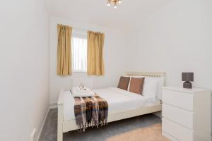 a white bedroom with a white bed and a window at 2BR with parking, Mill Hill, NW London, 10min Tube in Mill Hill