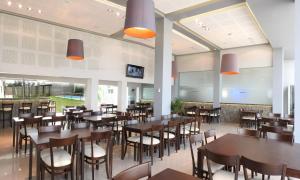 a restaurant with wooden tables and chairs and windows at Fábrica Hotel in Armstrong