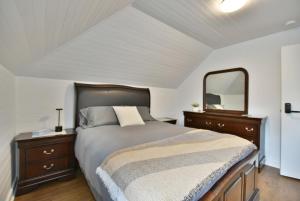 een slaapkamer met een groot bed en een spiegel bij Chambre 306 de l'hôtel Victoria confortable et moderne in Saint-Pascal