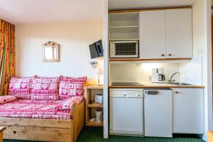 ein kleines Zimmer mit einem Bett und einer Küche in der Unterkunft Résidence Le Sextant - SEXTANT 107 MAE-4781 in La Plagne Tarentaise