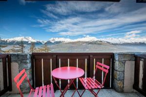 zwei rosa Stühle und ein Tisch auf einem Balkon mit schneebedeckten Bergen in der Unterkunft Résidence Le Sextant - SEXTANT 107 MAE-4781 in La Plagne Tarentaise