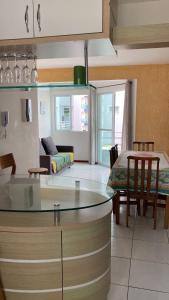 a kitchen and living room with a table and a couch at AP IVONETE -Victoria Residense in Governador Celso Ramos