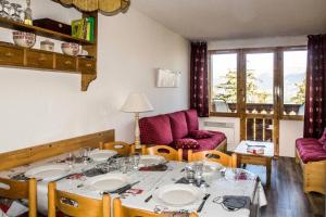 ein Esszimmer mit einem Tisch mit Tellern darauf in der Unterkunft Résidence Le Sextant - SEXTANT 110 MAE-0481 in La Plagne Tarentaise + 5 Fotos
