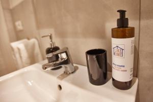 a bathroom sink with a bottle of mouthwash and a cup at LikeHome San Romano - 1 Rooms-3 persone-Ferrara in Ferrara