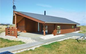 a small wooden cabin with a deck in a field at Holiday Home Klitsvinget Ringkøbing Ii in Klegod