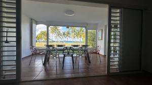 ein Esszimmer mit Tisch und Blick auf das Meer in der Unterkunft Be Marisol in Le Gosier