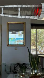 ein Esszimmer mit einem Tisch und zwei Fenstern in der Unterkunft Be Marisol in Le Gosier