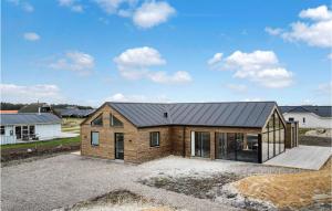une maison avec un toit en métal au-dessus d'une allée. dans l'établissement Nice Home In Harboøre With Sauna, à Harboør 22 autres photos