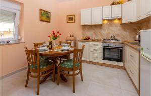 a kitchen with a table and chairs in a kitchen at Beautiful Apartment In Sisan With Wifi in Šišan