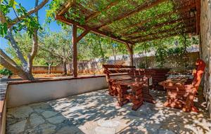 a patio with a pergola and two wooden benches at Awesome Home In Zaboric With Wifi in Zaboric +47 photos