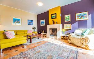 a living room with a yellow couch and a fireplace at Awesome Home In Zaboric With Wifi in Zaboric
