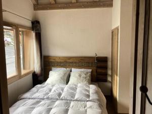 une chambre avec un lit avec des draps blancs et une fenêtre dans l'établissement Les Chalets De Wengen - CHALETS DE WENGEN 95 MAE-0861, à La Plagne Tarentaise