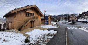 une maison en bois avec de la neige au bord d'une rue dans l'établissement Les Chalets De Wengen - CHALETS DE WENGEN 95 MAE-0861, à La Plagne Tarentaise