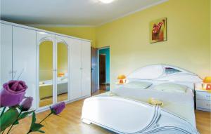 a bedroom with a white bed and a white cabinet at Holiday Home Livaki Iv in Muntrilj