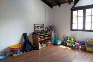 Un rincón de una habitación con una sala de juegos con un estante. en Espectacular casa en Olivos, en Olivos