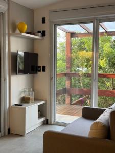 a living room with a sliding glass door to a deck at Pousada Ilha do Campeche in Florianópolis