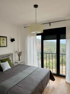a bedroom with a large bed and a large window at Tornik view villa Zlatibor 2 in Ribnica