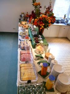 einem langen Tisch voller Lebensmittel und Teller mit Lebensmitteln in der Unterkunft Hotel Brandenburg in Königs Wusterhausen
