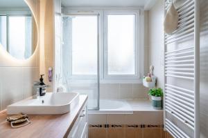 a bathroom with a sink and a tub and a window at 20mins à Paris, Rueil-Malmaison à côté de la gare in Rueil-Malmaison +11 photos