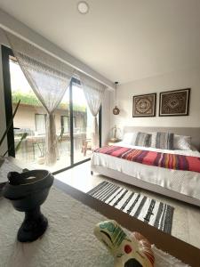 a bedroom with a bed and a large window at Estudio Asteroide in Tulum +8 photos