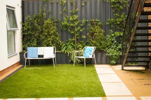 Dos sillas y una mesa en un patio con césped. en Eastbourne Central Apartment Short and Long Stay welcome, en Eastbourne