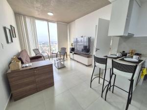 a kitchen and a living room with a counter and chairs at Apartamento con pileta en Asunción centro in Asunción