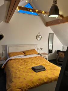 a bedroom with a bed with a yellow comforter at Beach hut seaside cottage in Sheringham