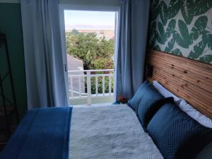 a bedroom with a bed and a large window at Brisa da Praia Residencial in Florianópolis +18 photos