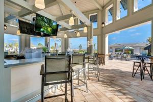 基西米Tranquility At Storey Lake By Shine Villas #828的一个带椅子的庭院和一间带平面电视的酒吧