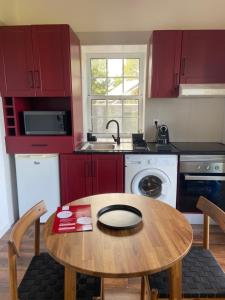 a kitchen with red cabinets and a wooden table at Refúgio da Montanha in Lajido +12 photos
