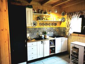 a kitchen with white cabinets and a yellow wall at Legowisko Bieszczady in Ropienka