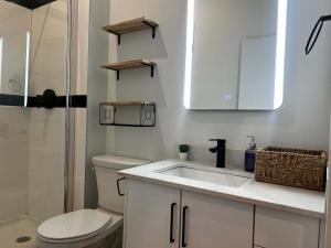 a white bathroom with a sink and a toilet at Urban Sophistication, Ocean View, Unit 513 in Halifax