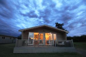 une petite maison avec un porche et une terrasse dans l'établissement Woodpecker Lodge - Brook Meadow - sleeps 4 plus 2 - no pets, à Market Harborough