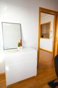 マドリードにあるApartamentos Madrid Andersonの鏡付きの部屋の白いドレッサー