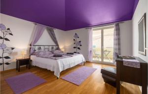 una camera con letto e soffitto viola di Four-Bedroom Holiday Home In Golubovo a Mednjan