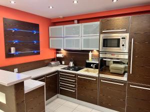 a kitchen with wooden cabinets and a microwave at Apartament Dona, Topazowa 4 in Lublin