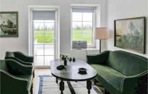 a living room with a couch and a table and two chairs at Holiday Home Bakkegårdsvej in Arup +6 photos