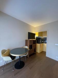 a room with a table and chairs and a kitchen at Royal lux promenade des anglais in Nice