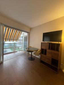 a living room with a table and a tv at Royal lux promenade des anglais in Nice
