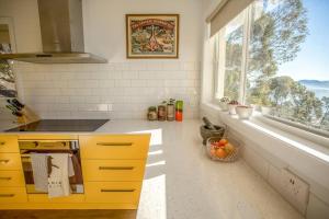 a kitchen with yellow cabinets and a large window at Sandy Bay Townhouse in Sandy Bay