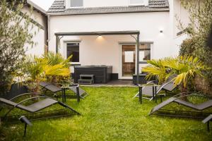 a patio with chairs and a grill in a yard at MODERNHOUSE KO26 in Koblenz