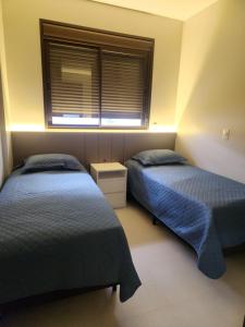 two beds in a room with a window at Mar de ensueños in Florianópolis +23 photos