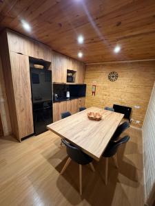 a wooden table in a kitchen with chairs around it at Mountain Lodge T3 Duplex Abrigo do Lobo in Covilhã