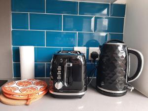two toasters on a kitchen counter with blue tiles at Super Central 2bed Central Reading - free parking in Reading