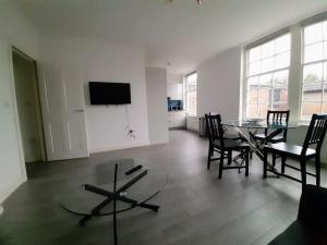 a living room with a table and chairs and a television at Super Central 2bed Central Reading - free parking in Reading
