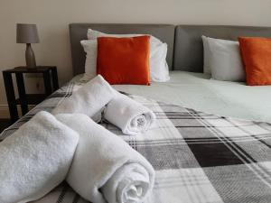 a bed with towels on top of it at Super Central 2bed Central Reading - free parking in Reading
