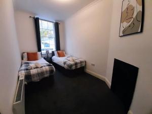 a room with two beds and a window at Super Central 2bed Central Reading - free parking in Reading +5 photos
