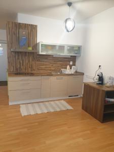 a kitchen with a counter and a wooden floor at Apartman Triangel 1-04 in Donovaly